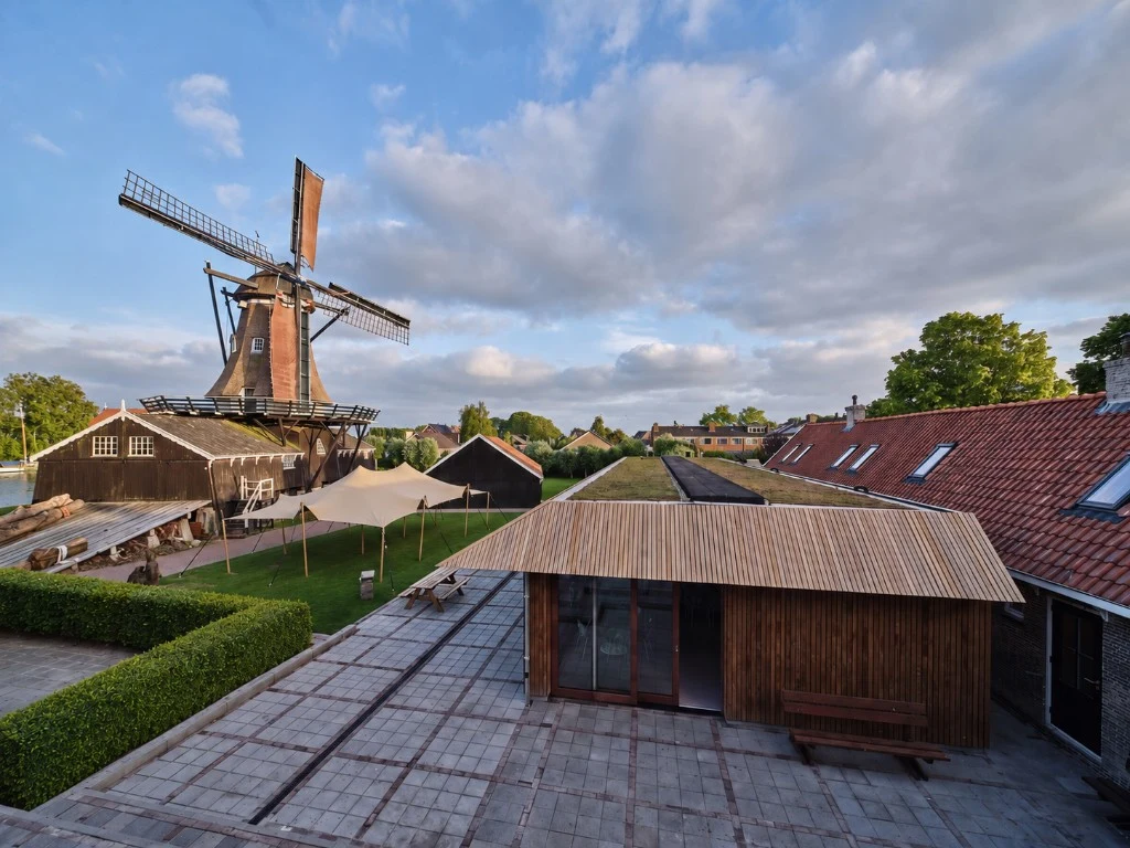 Binnenplaats van Het Molenhuis met houtzaagmolen, stretchtent en houten paviljoen