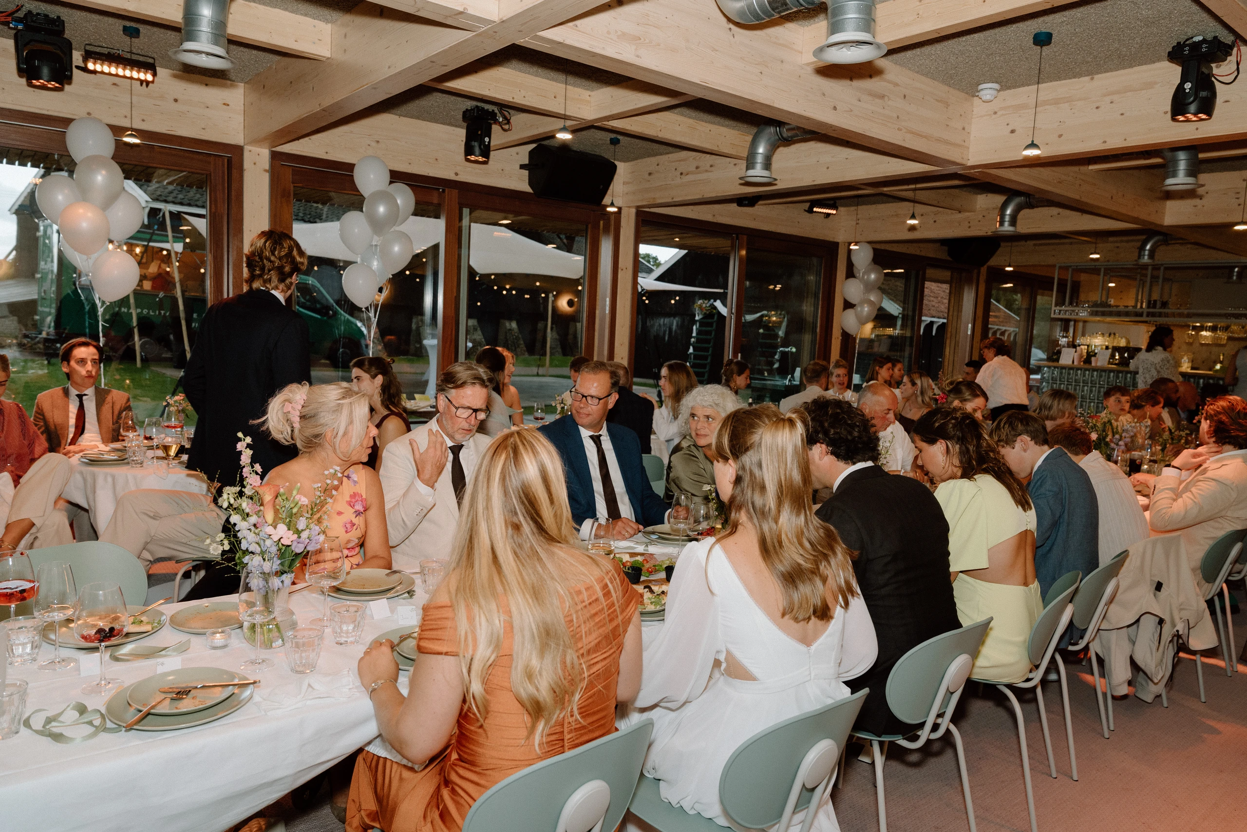 Gasten aan lange dinertafel in het paviljoen van Het Molenhuis