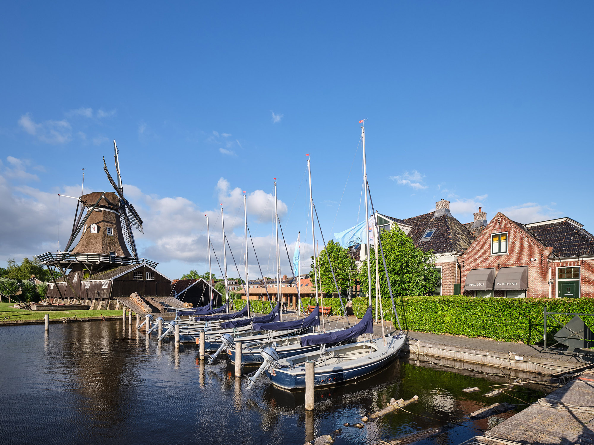Haven van Woudsend met molen, zeilbootjes en Beurs Hus aan het water
