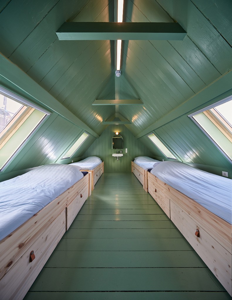 Zolderkamer met meerdere houten bedden in Het Molenhuis