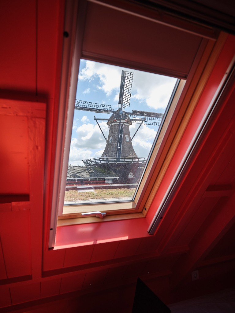 Uitzicht op de houtzaagmolen vanuit de rode zolderkamer in Het Molenhuis