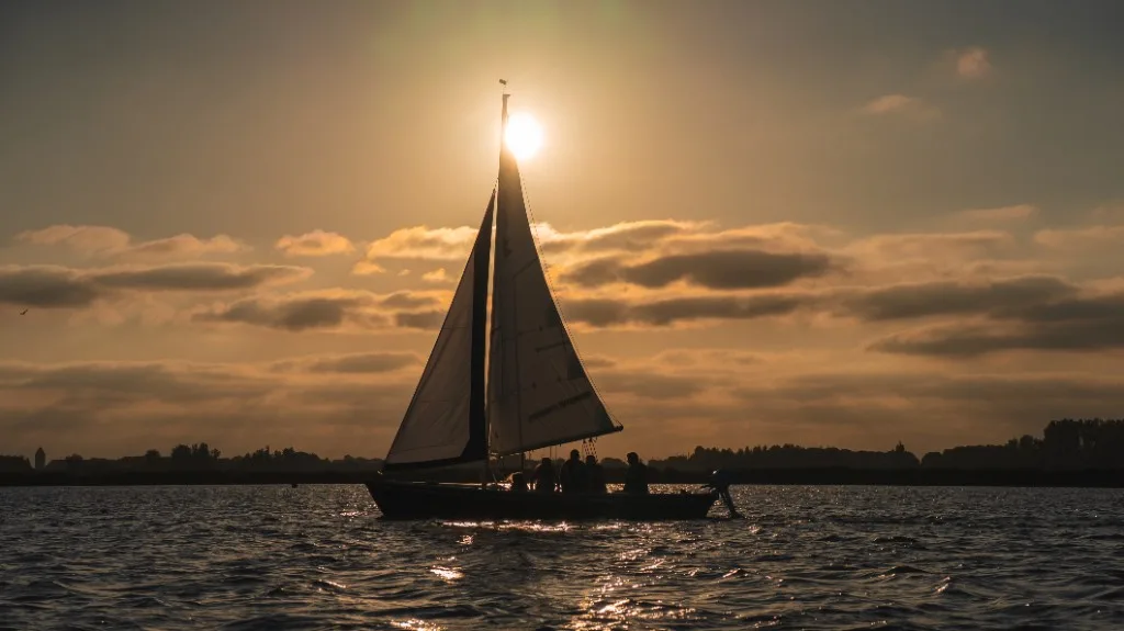 Zeilboot op het water bij zonsondergang in Woudsend